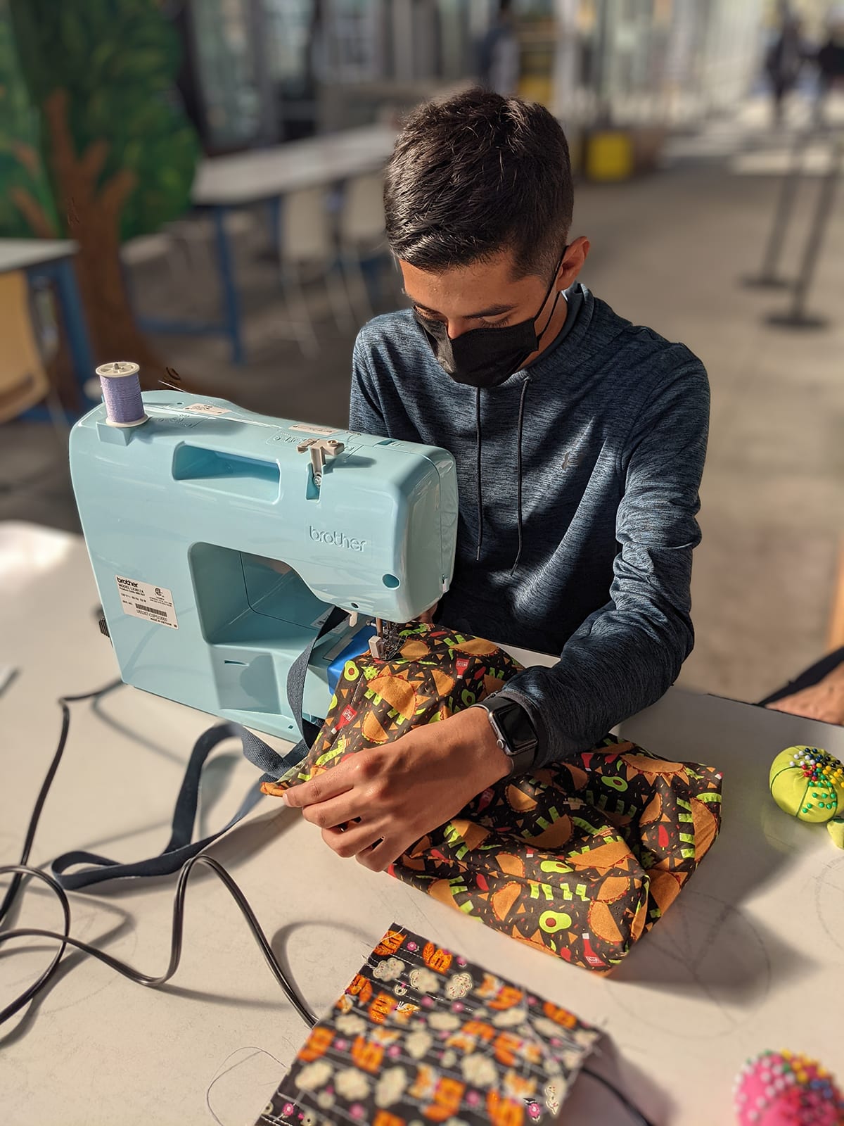 Photo of a male student working on a sewing machine