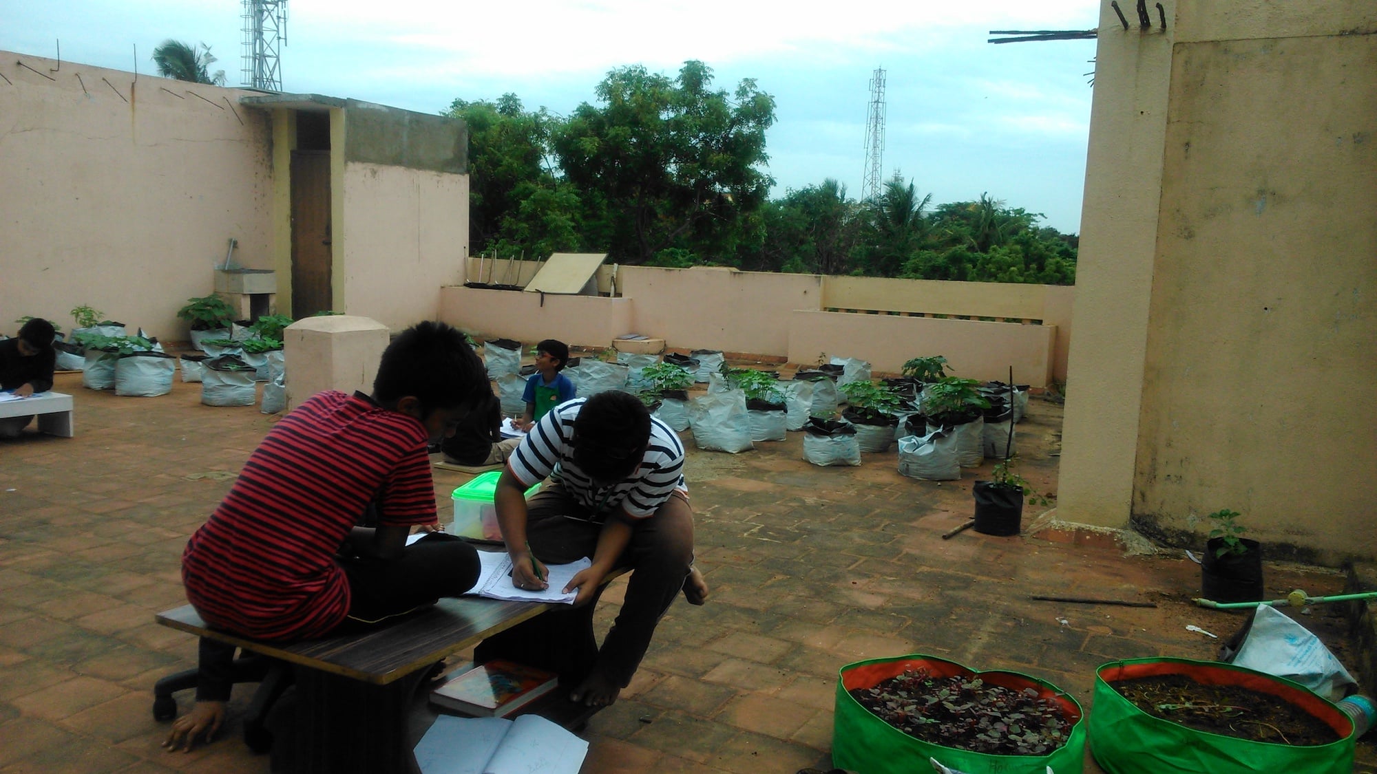 Kids doing work outdoors on a tiled floor