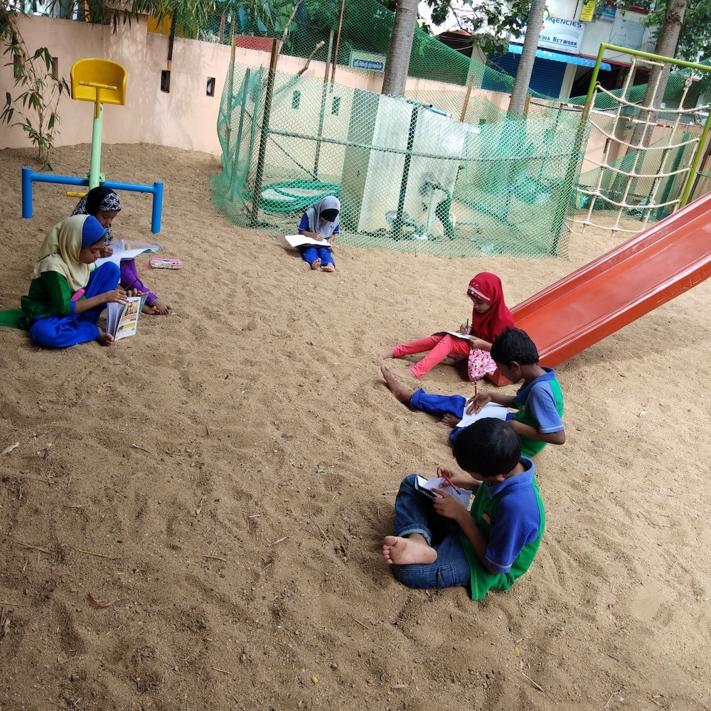 Kids reading on a sandy playground