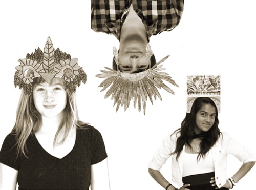 Three people wearing elaborate paper crowns pose playfully. One person is upside down at the top, another smiles on the left, and a third stands confidently on the right. The image is in grayscale with a stark white background.