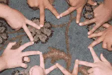 A group of hands, belonging to members of the titular organization, interlock their fingers to form star shapes on a patterned carpet. The varied skin tones reflect the diversity among participants.