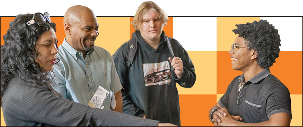 A group of four people are engaged in a conversation. Three are facing a smiling person with curly hair. The atmosphere appears friendly. The background features an orange and white checkered pattern.