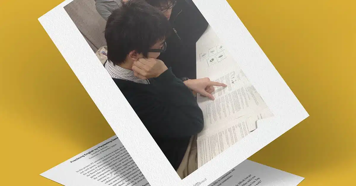 A person in glasses and a dark sweater is reading an English document, pointing at a specific section. The document appears to have multiple paragraphs and symbols, possibly related to playtesting. The image is angled on a yellow background, overlaid on another sheet of text.