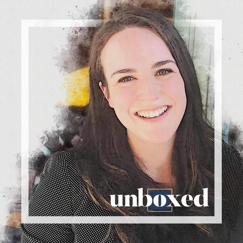A digital artwork of a woman with long dark hair smiling, set against a watercolor background. The word unboxed is partially overlaid on her photo in the lower right corner within a white square frame, symbolizing support and mental health awareness in the classroom.