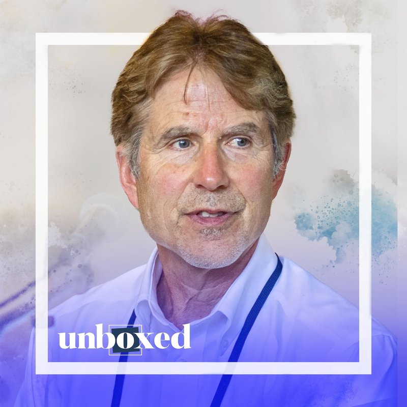 A man with brown hair, wearing a white shirt and blue lanyard, is framed by a white square. The watercolor-textured background complements the images bottom text, unboxed, in white over a blue gradient. This design echoes Ron Bergers emphasis on visual presentations and learning.