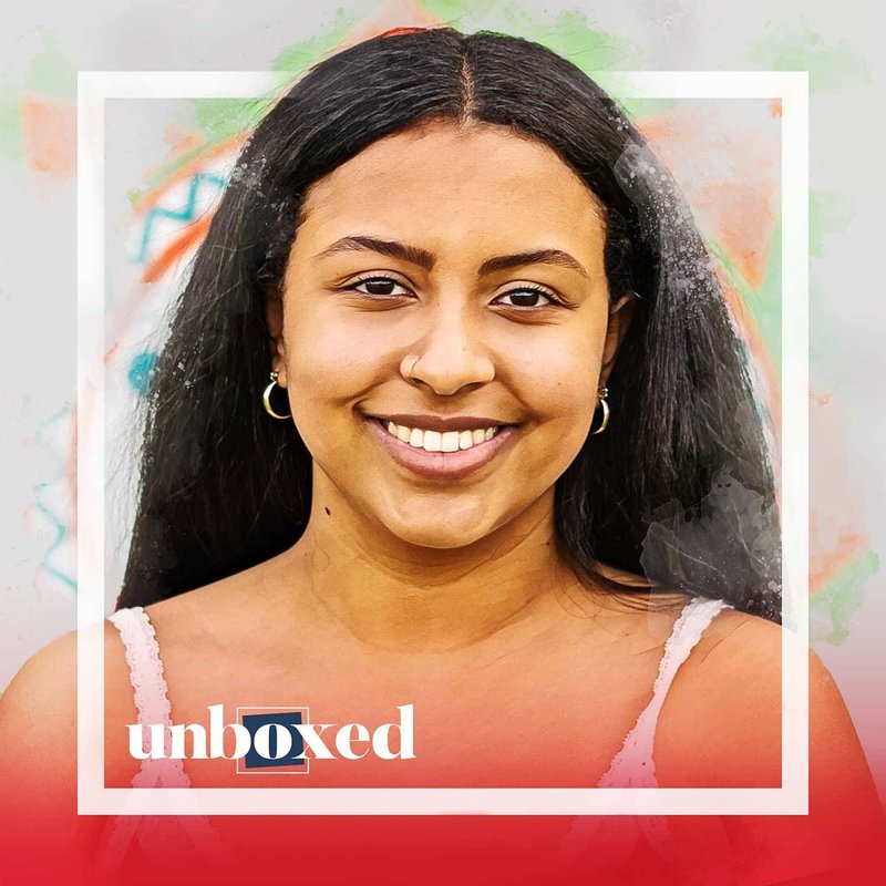 A smiling person with long dark hair is in the center of the image, surrounded by an artistic background with geometric patterns reminiscent of California’s vibrant life. The word unboxed is displayed at the bottom with a blue box around the letter b.