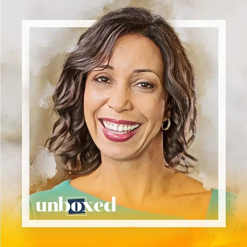 A smiling person with wavy hair is framed within a square, embodying the spirit of Changing the World. They are wearing a green top and hoop earrings. The word unboxed is displayed near the bottom, against a backdrop of soft colors.