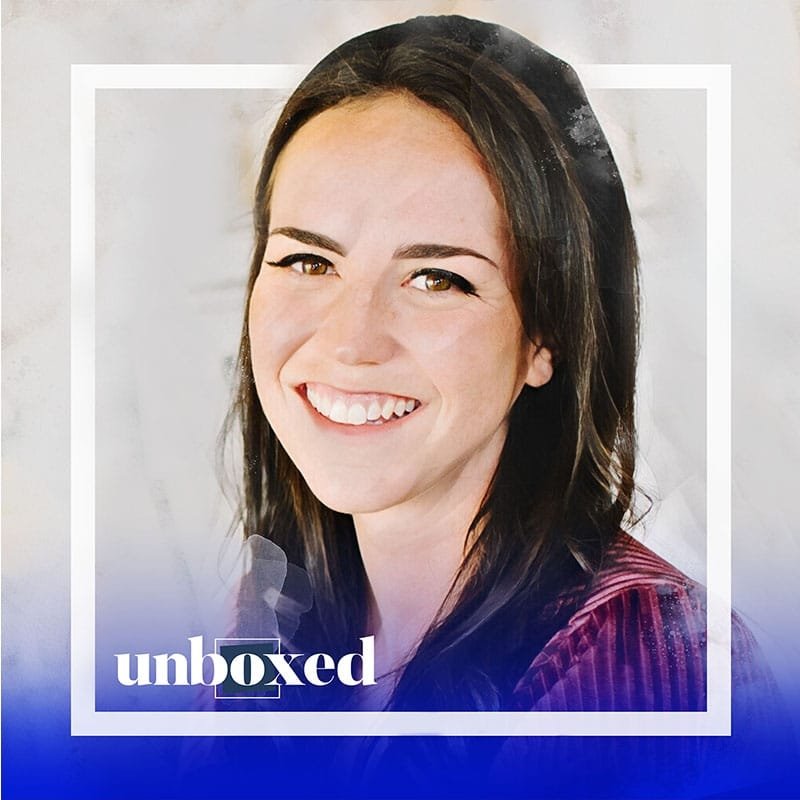 Smiling person with long dark hair wearing a striped top. The image has a blue gradient at the bottom with the word unboxed written across it in white text, subtly highlighting the importance of mental health conversations.