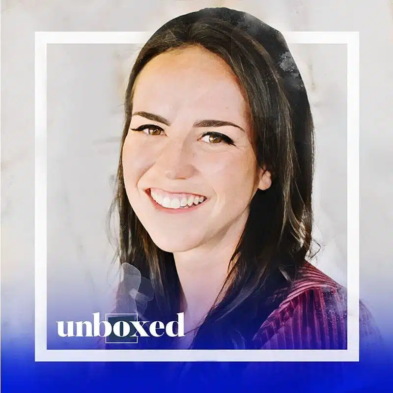 Smiling person with long dark hair wearing a striped top. The image has a blue gradient at the bottom with the word unboxed written across it in white text, subtly highlighting the importance of mental health conversations.