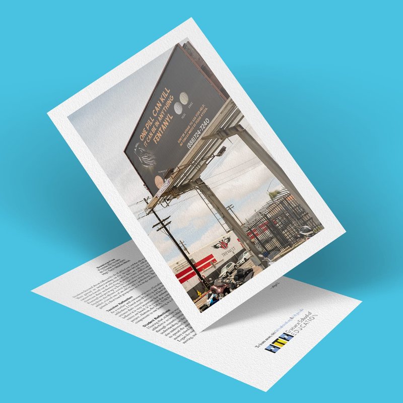 A greeting card with a photo mounted on a blue background. The image captures a street scene with a billboard advertising a law firm, amidst cars and power lines, symbolizing the essence of breaking free. Inside, youll find thoughtful text and a small logo.