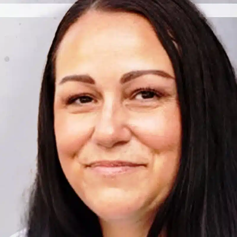 The image features Jessica Waters, her long dark hair framing a slight smile, as she faces the camera against a light gray background.