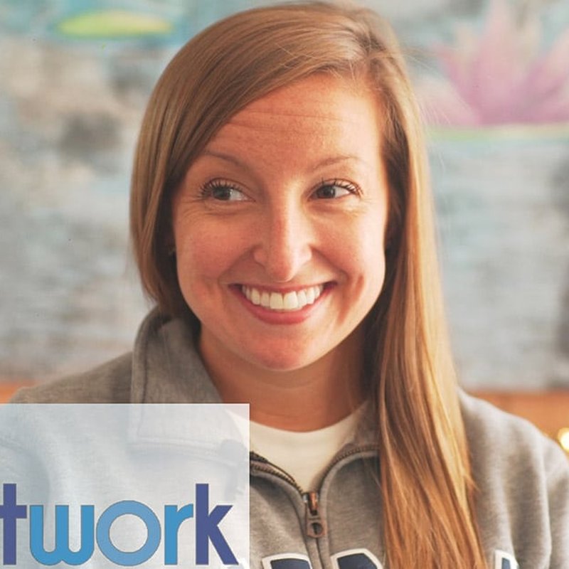 A person with long light brown hair smiles warmly, wearing a gray sweatshirt. Behind them, a softly blurred mural adds color, and part of a logo with twork suggests a connection to North County or the CARE Network in the bottom left corner.