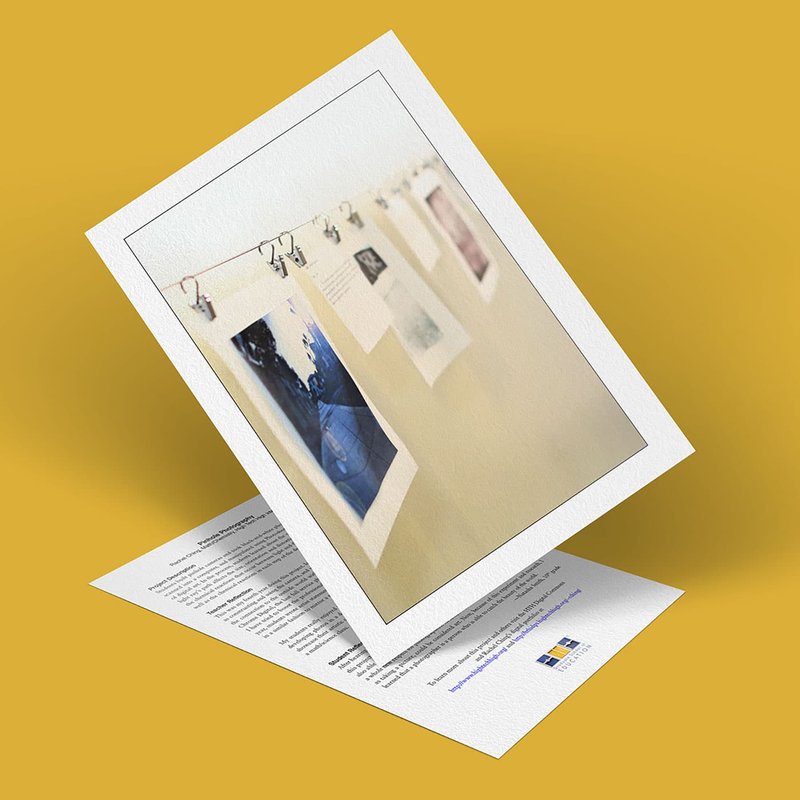 A printed photo of pinhole images hanging on a wall is propped up against a document with text and a small blue and yellow logo, all on a yellow background.