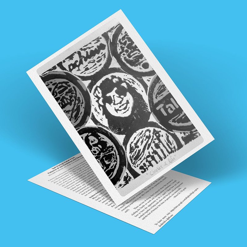 A greeting card with a black and white design reminiscent of relief prints features a central lion face surrounded by circular shapes. The card is shown partially open against a blue background.
