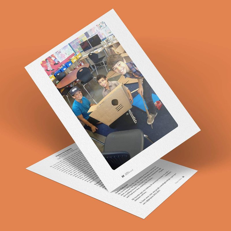 A polaroid photo of three children smiling and playing with cardboard boxes in a classroom setting, resting on a sheet of paper titled Raptors for Rodents. The background is a solid orange color.