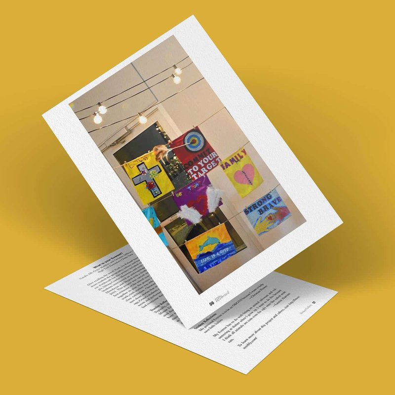A colorful art display featuring various signs and paintings, inspired by personal challenges, hangs on a wall under string lights. The artwork includes abstract designs and phrases like Do Your Own Thing and Anything is Art. A white border frames the image.