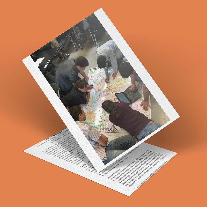 In a vibrant scene titled Faces of South County, a group collaborates over a colorful map on the floor, surrounded by chairs. Some use markers while one works on a laptop, all captured against an orange background.