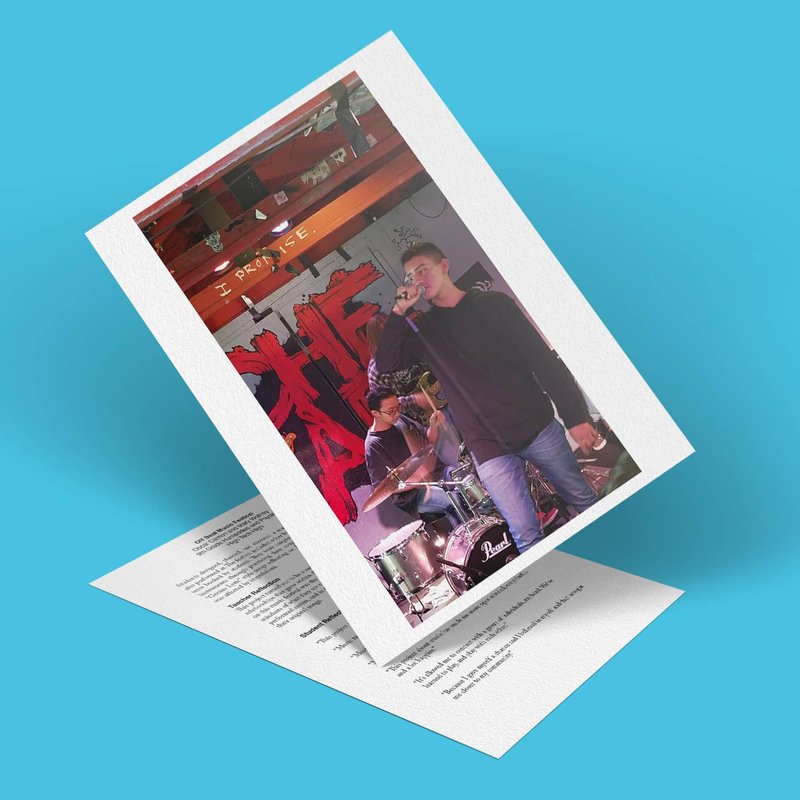 A photo of a man singing into a microphone and a drummer playing drums at the Off Beat Music Festival, overlaid on a blue background. The image has a paper texture and a handwritten element at the bottom, capturing the lively and colorful ambiance.