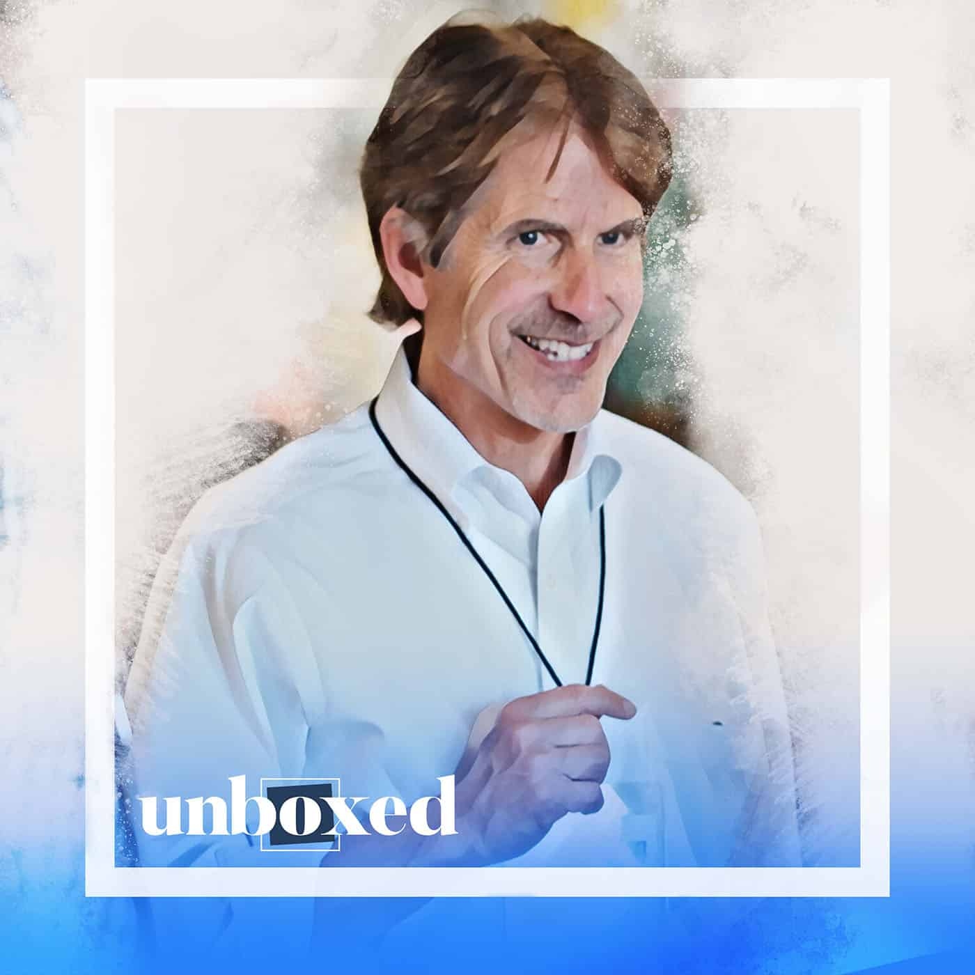 A smiling man in a white shirt holds a black lanyard, reminiscent of Ron Berger at Student Led Conferences. The image has a watercolor effect with a blue gradient at the bottom. The word unboxed is written in lowercase in the bottom left corner.