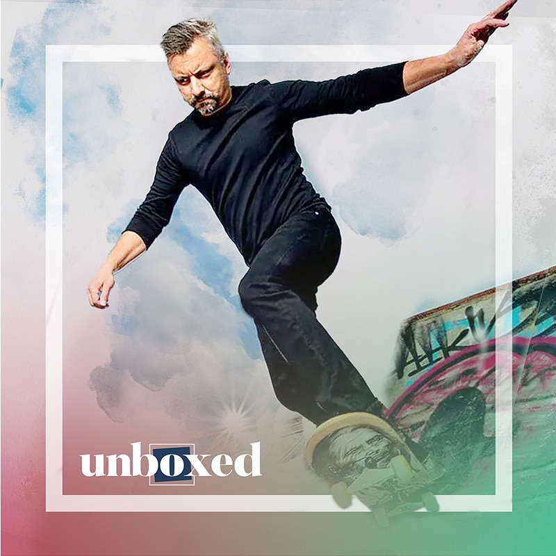 A man skateboards daringly along the edge of a graffiti-covered structure. Donning a black shirt and pants against the sky, he embodies the spirit of freedom. The word unboxed appears in the corner, subtly nodding to Canadas Indigenous History with its logo design.