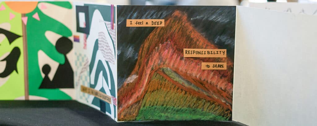 A colorful, handmade art display from Project Unpacking shows a mountain scene with the words I feel a deep responsibility to share on brown paper, surrounded by other abstract, vibrant drawings.