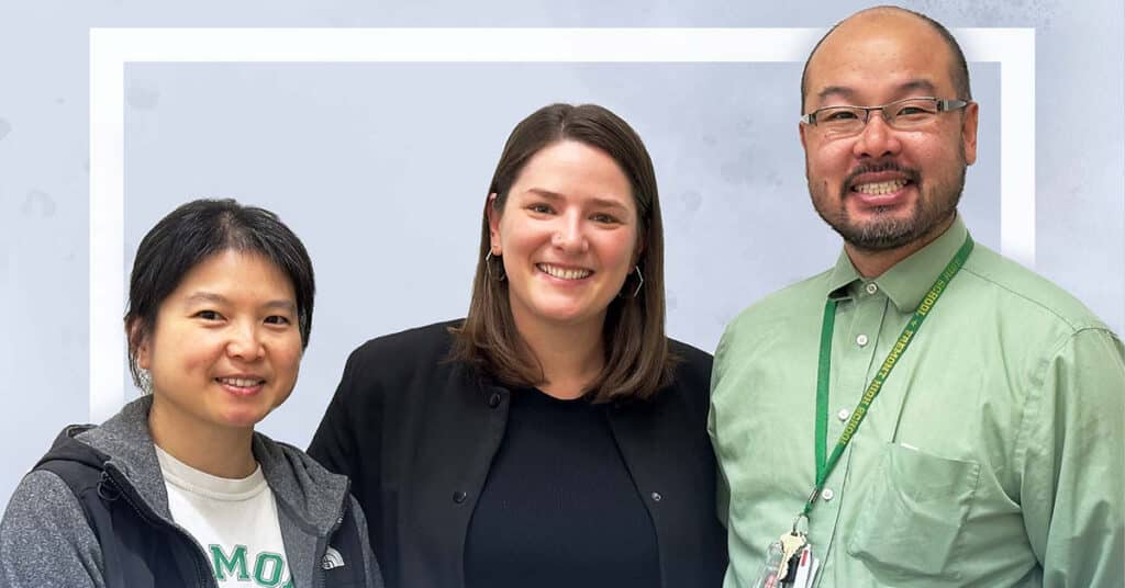 Three adults stand closely together, smiling at the camera. The person on the left wears a casual jacket and T-shirt, while the person in the middle sports a black blazer. On the right, someone with glasses and a Fremont High School lanyard wears a green shirt.