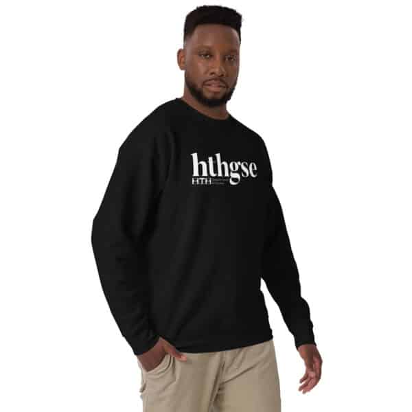 A man with short hair and a beard wears a black crew neck sweatshirt with "hthgse" and "FITH" white logo, paired with light khaki pants, standing against a plain white background.