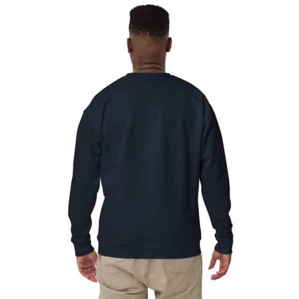 A person with short hair, wearing a navy blue Unisex Crew Neck Sweatshirt featuring a white logo and beige pants, is standing and facing away from the camera, showcasing the back of the sweatshirt.