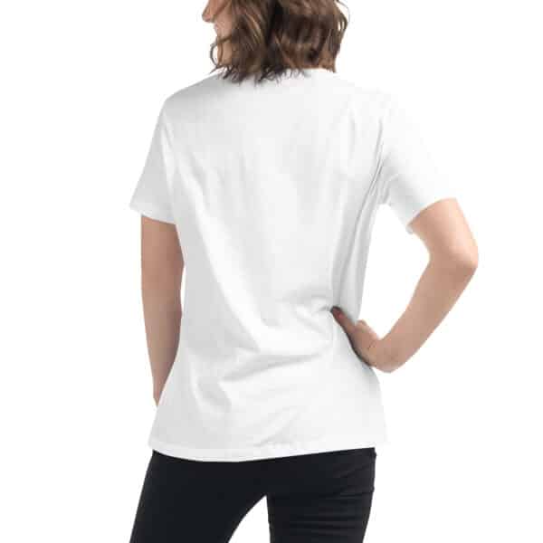 A person with shoulder-length brown hair is standing with their back to the camera, wearing a plain white women’s t-shirt and black pants, with one hand resting on their hip.