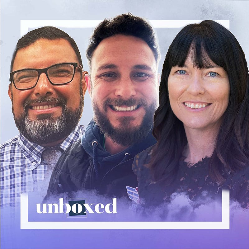 Three smiling people, two men and one woman, are positioned side by side in front of a cloud-themed background with a white square border. The word “unboxed” appears at the bottom.